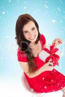 Composite image of smiling brunette sitting and opening gift