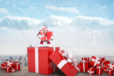 Composite image of santa standing in large gift