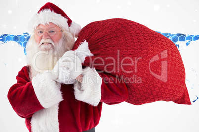 Composite image of santa carries his red bag and smiles