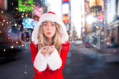 Composite image of pretty santa girl blowing over hands