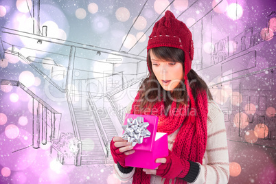 Composite image of festive brunette opening a gift