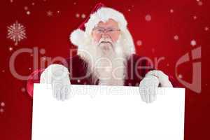 Composite image of santa is holding a sign