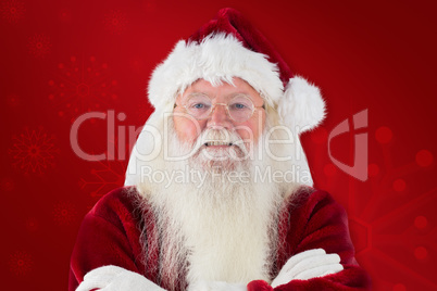 Composite image of santa smiles with folded arms