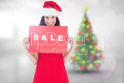 Composite image of festive brunette in red dress holding sale si