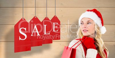 Composite image of happy festive blonde with shopping bag