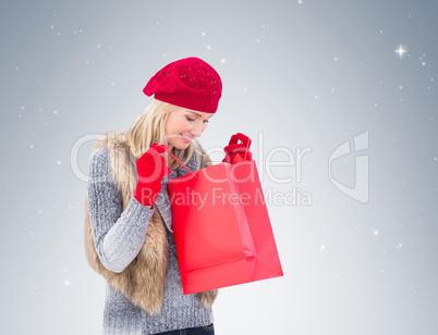 Blonde in winter clothes looking in shopping bag