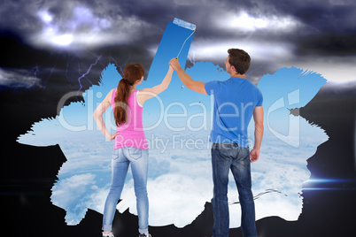 Composite image of couple painting a wall together