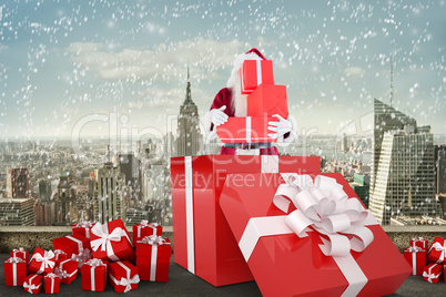 Composite image of santa standing in large gift