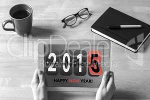 Composite image of businesswoman holding tablet at desk