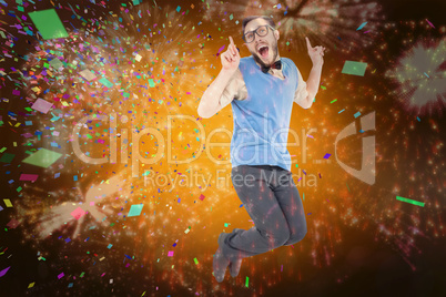 Composite image of geeky hipster jumping and smiling