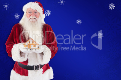 Composite image of santa holds a tiny house in his hands