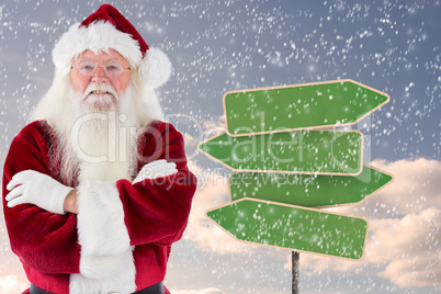 Composite image of santa smiles with folded arms