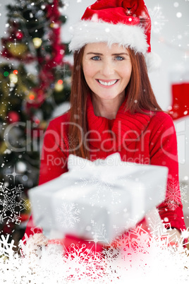 Composite image of festive redhead holding christmas gifts