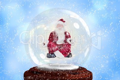 Composite image of santa doing yoga in snow globe