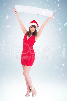 Composite image of young woman holding up empty banner