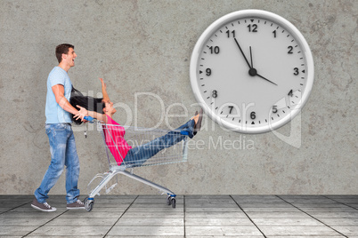 Composite image of young couple having fun with shopping cart