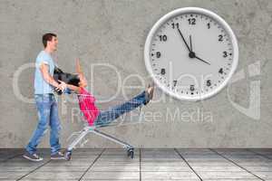 Composite image of young couple having fun with shopping cart