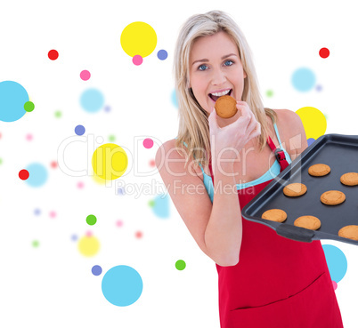 Composite image of happy blonde eating hot cookies