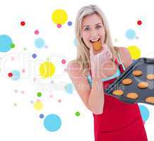 Composite image of happy blonde eating hot cookies