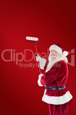 Composite image of father christmas paints a wall