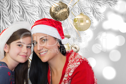 Composite image of mother and daughter in santa hats