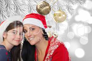 Composite image of mother and daughter in santa hats