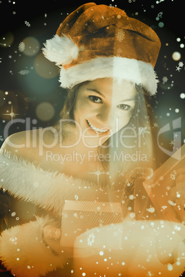 Composite image of pretty brunette in santa outfit opening gift