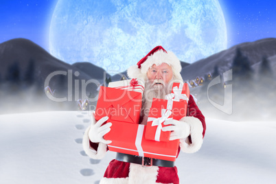 Composite image of santa carrying gifts in the snow