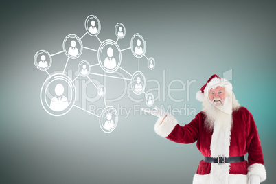 Composite image of santa shows something to camera