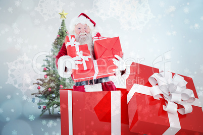 Composite image of santa standing in large gift