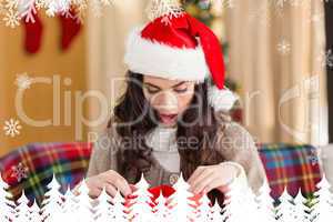 Composite image of brunette looking in gift bag at christmas