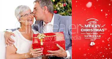 Composite image of senior man giving a kiss and a christmas pres