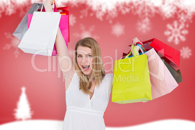 Composite image of blonde woman raising shopping bags