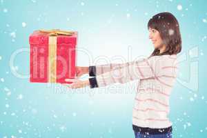 Composite image of cute young woman holding a gift