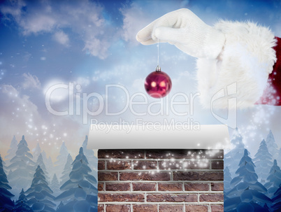 Composite image of santas hand is holding a christmas bulb