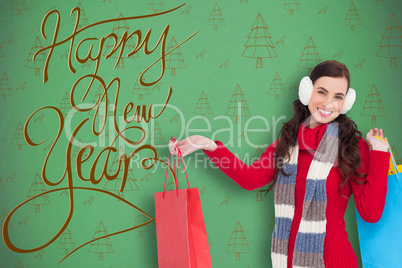 Composite image of brunette in winter clothes holding shopping b