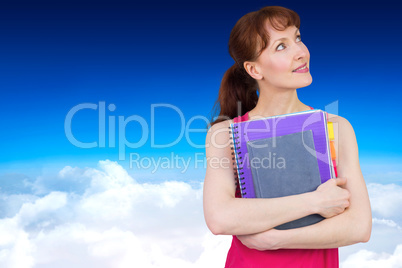 Composite image of woman holding her school notebooks