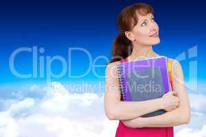 Composite image of woman holding her school notebooks