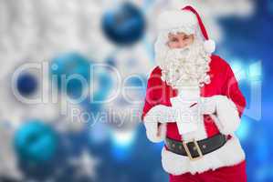 Composite image of happy santa holding paper and pen
