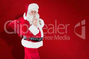 Composite image of santa keeping a secret and holding his sack