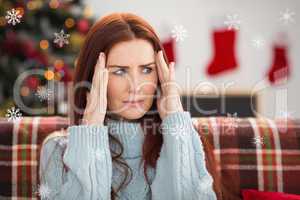Composite image of woman getting a head ache at christmas