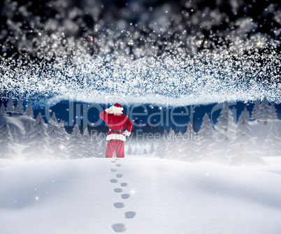 Composite image of santa walking in the snow