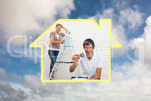 Composite image of smiling couple painting a wall