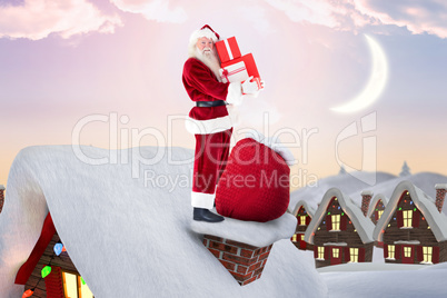 Composite image of santa on cottage roof