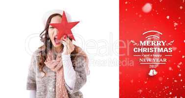 Composite image of excited brunette in winter clothes holding st