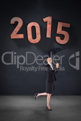 Composite image of businesswoman holding a black umbrella