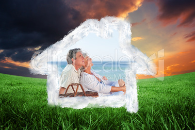 Composite image of elderly couple picniking on the beach