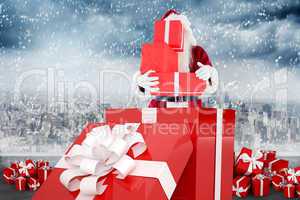 Composite image of santa standing in large gift