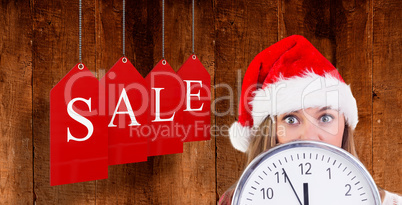 Composite image of festive blonde showing a clock