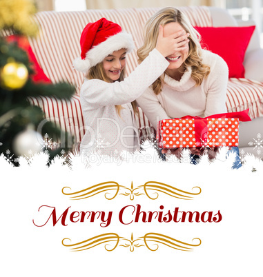 Composite image of festive mother and daughter with gift